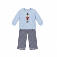 A two-piece children's outfit set from the brand 'Squiggles' featuring a light blue long-sleeve top with a colorful nutcracker graphic on the chest, paired with navy and white horizontally striped pants.