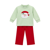 A two-piece children's holiday outfit featuring a light green long-sleeve top with a red and white Santa Claus face applique on the chest, paired with solid red pants, shown against a plain white background.