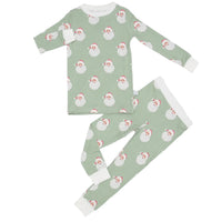 A two-piece children's pajama set featuring a light sage green background with a repeating pattern of cartoon Santa Claus faces. The pajamas include a long-sleeve top with white cuffs and a matching pair of pants with white cuffs and a white button placket. | Boys Sleigh Bells Loungewear Set by Hamner Hill