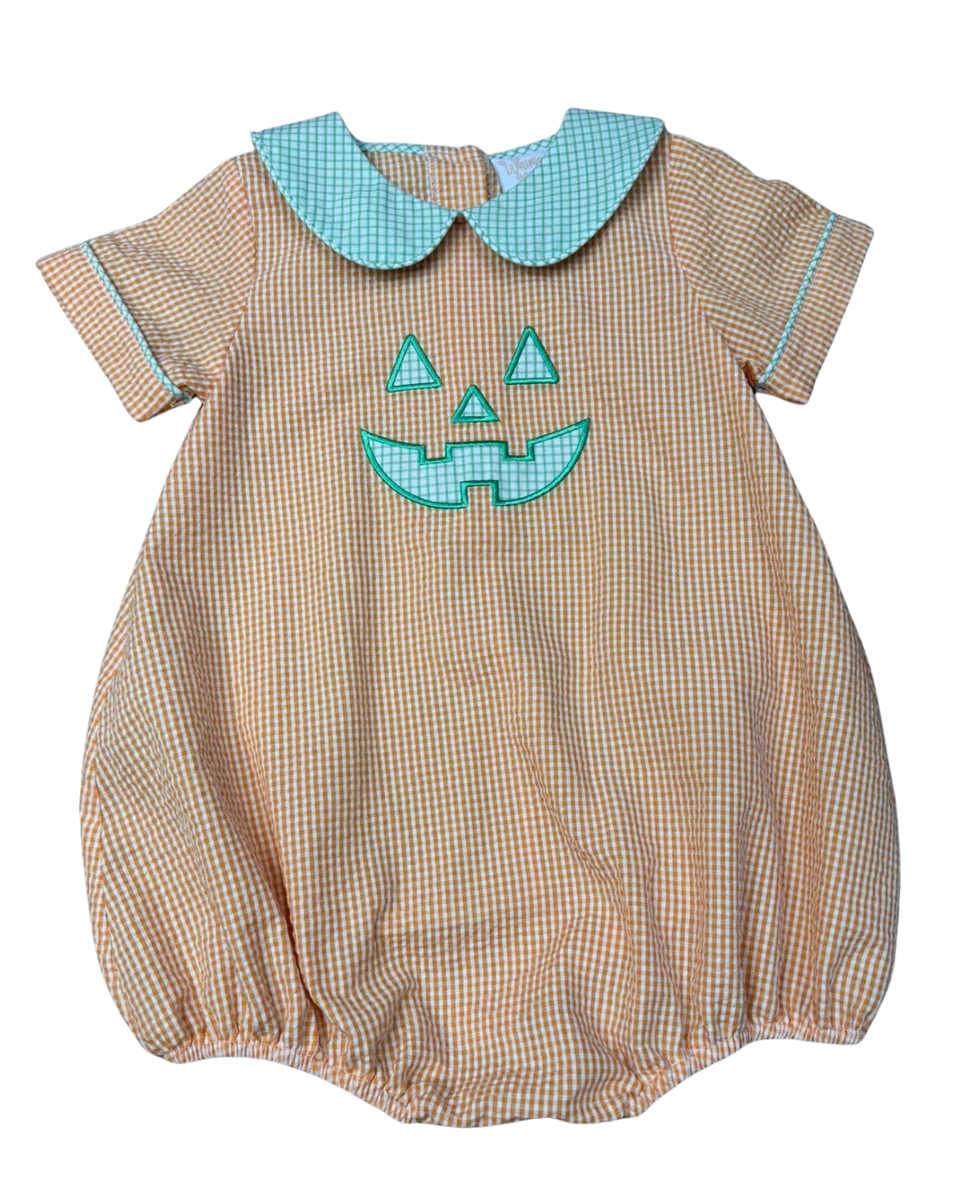 A short-sleeve baby romper in a beige and white gingham pattern, featuring a light blue Peter Pan collar and a light blue embroidered jack-o'-lantern face on the chest.