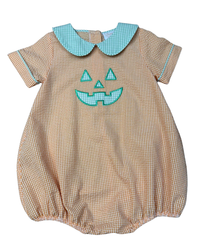 A short-sleeve baby romper in a beige and white gingham pattern, featuring a light blue Peter Pan collar and a light blue embroidered jack-o'-lantern face on the chest.