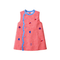 A sleeveless red and white gingham dress with blue ruffle trim, blue buttons, and small blue and red geometric appliques, shown flat on a white background.