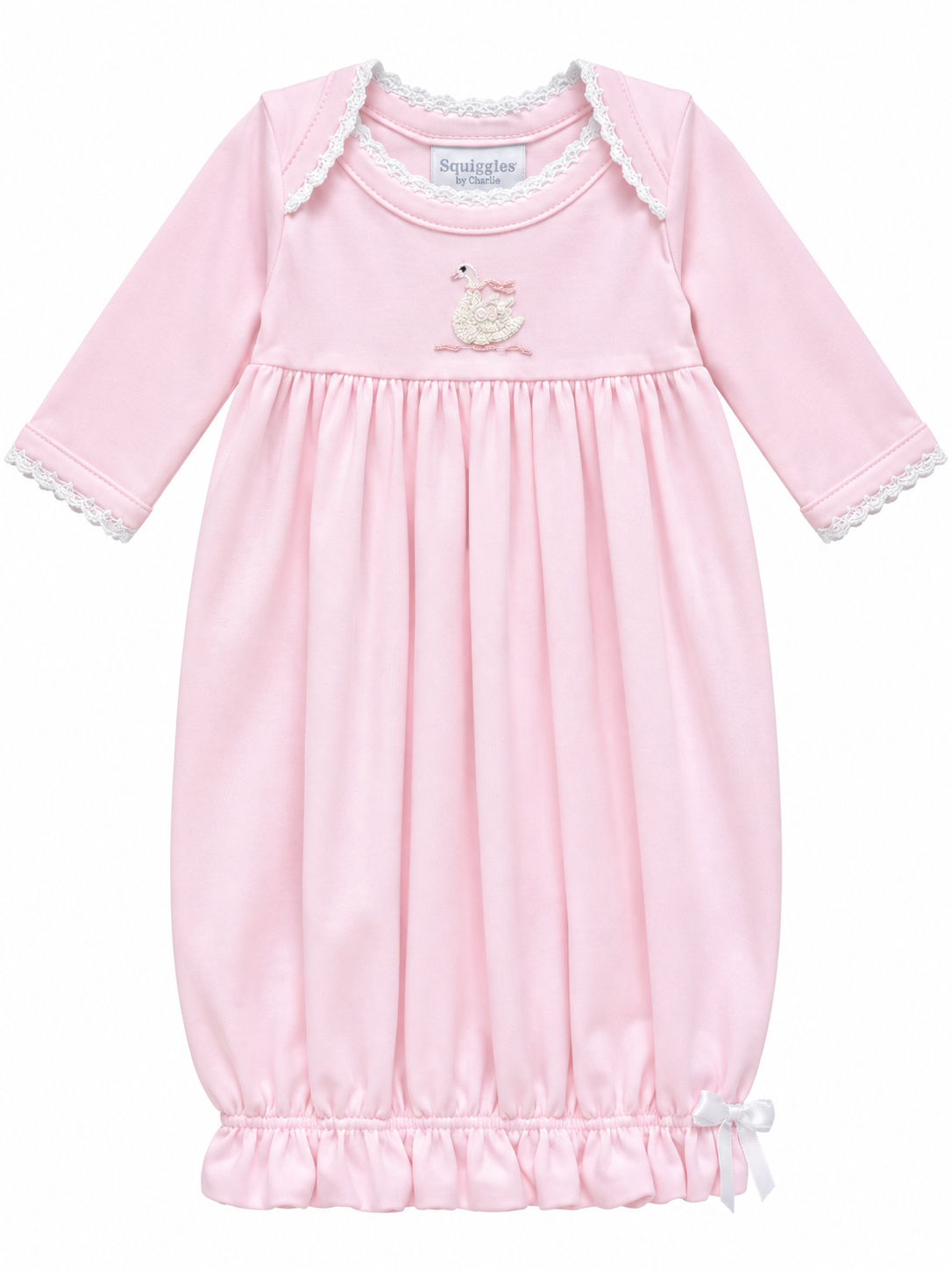 A pink long-sleeve baby nightgown with white lace trim on the collar and cuffs, featuring a small embroidered swan motif on the chest and a ruffled hem with a small white bow.