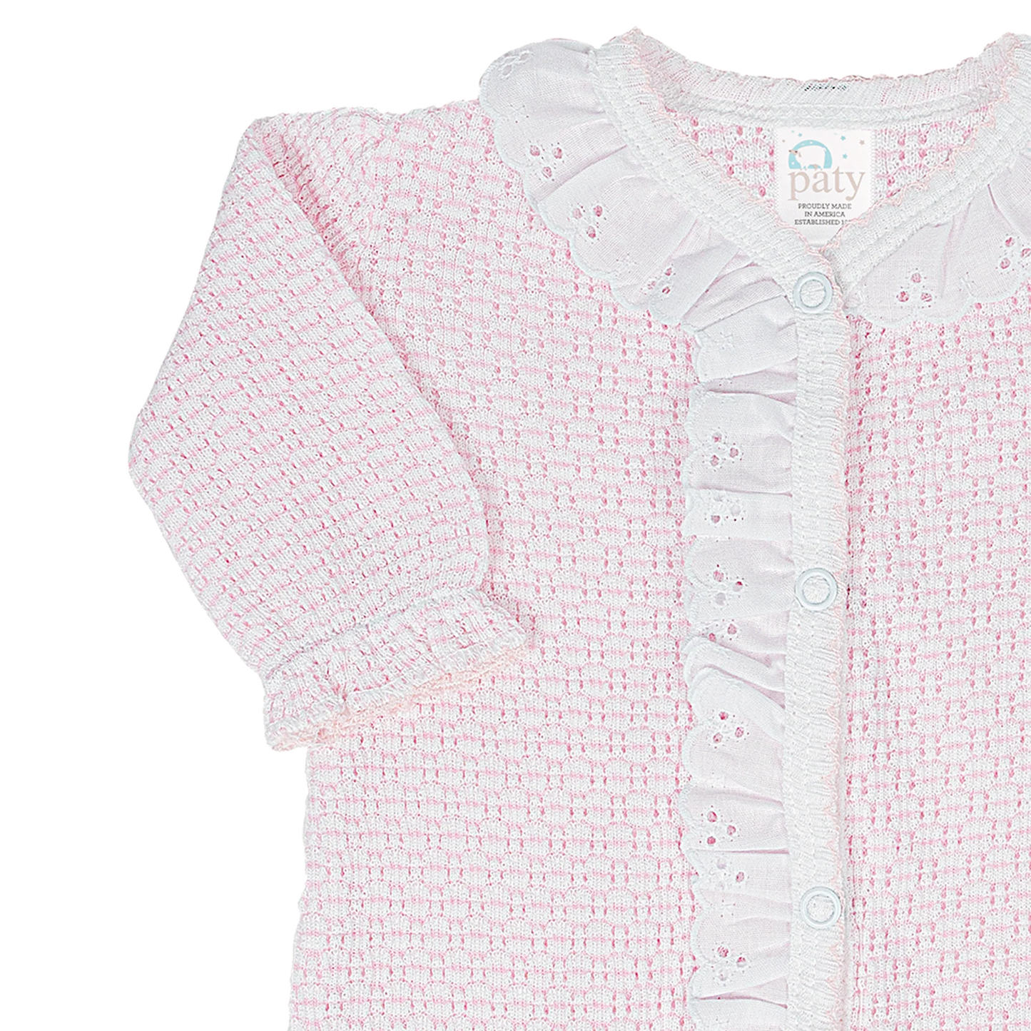 A close-up of a baby cardigan featuring a textured pink and white bouclé fabric, long sleeves, and a white eyelet ruffled collar and button placket. The brand label 'paty' is visible inside the collar.