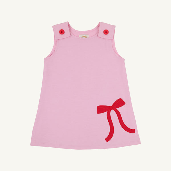 A light pink sleeveless baby dress with red button closures on the shoulders and a red bow detail on the lower right side, shown against a plain white background.